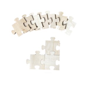 Peut inclure: Un ensemble de pi&egrave;ces de puzzle en bois en forme de point d'interrogation. Les pi&egrave;ces sont dispos&eacute;es en ligne courbe en haut de l'image, et trois pi&egrave;ces sont dispos&eacute;es en forme de triangle en bas de l'image.
