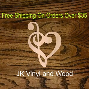 May include: A wooden cutout of a treble clef and heart design. The cutout is light brown and is on a dark brown wood background. The text "JK Vinyl and Wood" is at the bottom of the image.