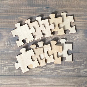 Peut inclure: Un ensemble de pi&egrave;ces de puzzle en bois dispos&eacute;es en rang&eacute;e sur une surface en bois brun. Les pi&egrave;ces sont toutes de la m&ecirc;me taille et de la m&ecirc;me forme, et elles ont une finition en bois naturel.