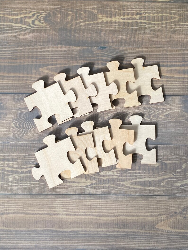 Peut inclure: Un ensemble de pi&egrave;ces de puzzle en bois dispos&eacute;es en rang&eacute;e sur une surface en bois brun. Les pi&egrave;ces sont toutes de la m&ecirc;me taille et de la m&ecirc;me forme, et elles ont une finition en bois naturel.