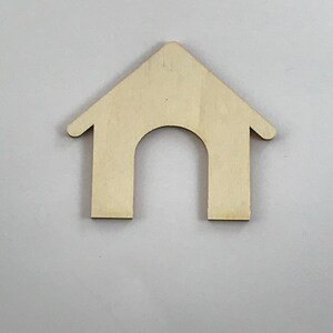 May include: A wooden cutout of a house with a rounded roof and a rectangular door opening. The cutout is light brown and has a smooth surface.