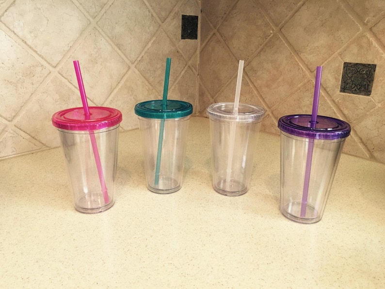 May include: Four clear plastic tumblers with lids and straws. The lids are pink, teal, clear, and purple. The straws are pink, teal, clear, and purple.