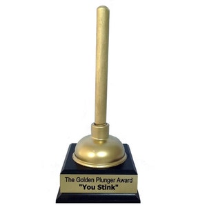 May include: A gold-colored plunger award on a black base with the text "The Golden Plunger Award" and "You Stink" on a gold plaque.