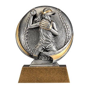 May include: A softball trophy featuring a silver-colored female softball player in action, set against a baseball-shaped backdrop with gold accents. The trophy is mounted on a rectangular, bronze-colored base.