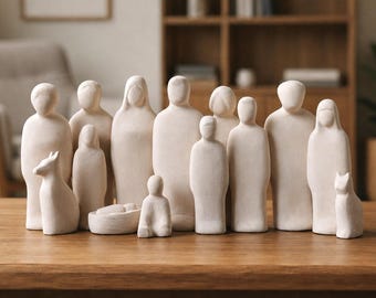 May include: A collection of twelve off-white, matte-finish figurines depicting human figures and animals. The set includes standing adults, a small seated figure, a figure in a cradle, and two animal figures, all with smooth, featureless faces.
