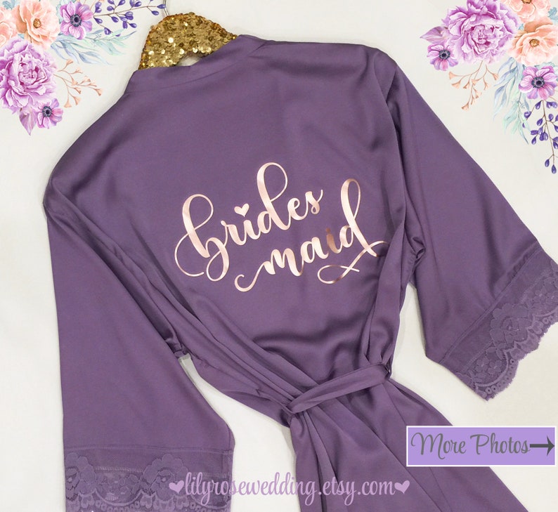 May include: Purple satin robe with lace trim and the words "bridesmaid" in rose gold lettering.