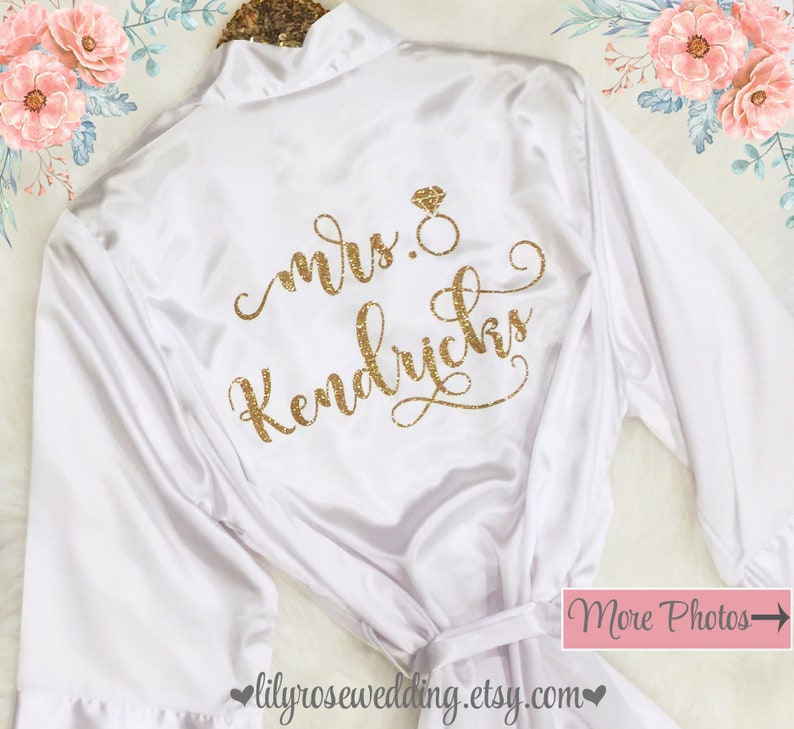 May include: White satin robe with a gold glitter design that says "mrs. Kendricks" with a diamond ring symbol.