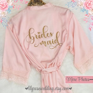 May include: Pink satin robe with lace trim and gold glitter lettering that says "bridesmaid".