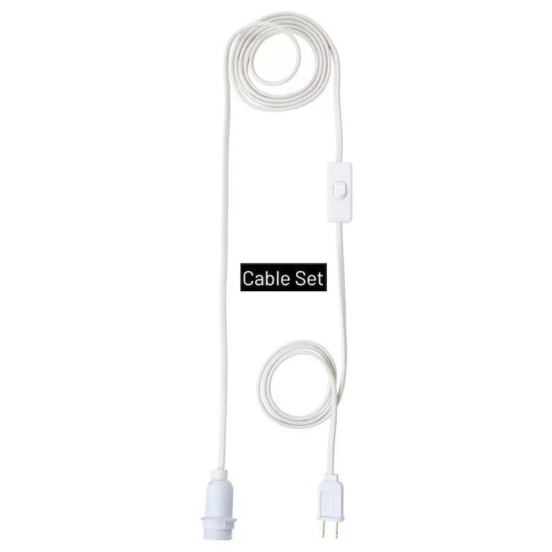 May include: A white cable set with a light socket, on/off switch, and a two-prong plug. The text "Cable Set" is displayed in a black box. The cable is coiled in a circular pattern.