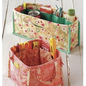 May include: Two fabric storage organizers with multiple pockets. The top organizer is yellow with green trim and floral print. The bottom organizer is red with a floral print. Both organizers are filled with various items, such as pens, pencils, a ruler, and a can of soda. The text "Pockets To Go" is printed on the bottom of the image.
