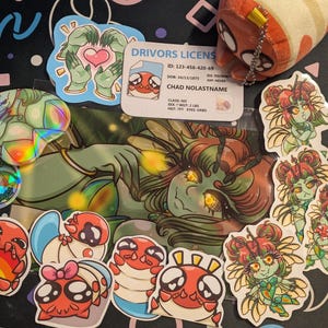May include: A collection of stickers, a plush toy, and a driver's license. The stickers feature various cartoon characters, including a green-skinned figure and several red and orange bug-like creatures. The driver's license has the name "CHAD NOLASTNAME".