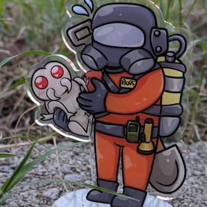 Könnte beinhalten: Eine Comic-Illustration eines Raumfahrtanzugs in Rot und Schwarz, der ein kleines, weißes, außerirdisch aussehendes Wesen hält. Der Charakter trägt einen schwarzen Helm mit einem klaren Visier und eine schwarze Gasmaske. Der Charakter hat einen gelben und schwarzen Rucksack und eine Schaufel. Der Charakter ist mit "Boss" beschriftet.