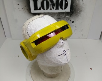 May include: Yellow plastic costume goggles with red tinted lenses. The goggles have a rounded, futuristic design.