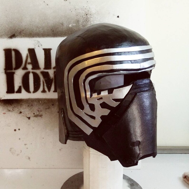 May include: A black and silver helmet with a textured surface and a visor. The helmet has a design of multiple silver lines across the top.
