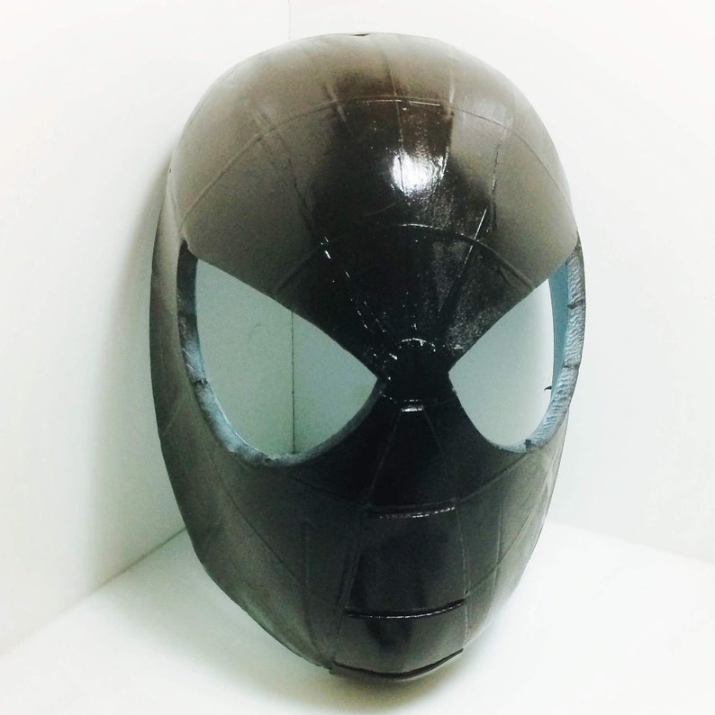 May include: Black and gray plastic mask with a spider web design. The mask has two eye holes and a small mouth hole.
