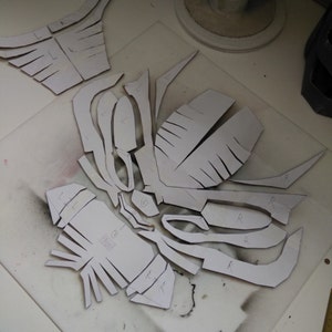 May include: A set of paper patterns for a costume, with markings for left and right sides. The patterns are laid out on a white surface.