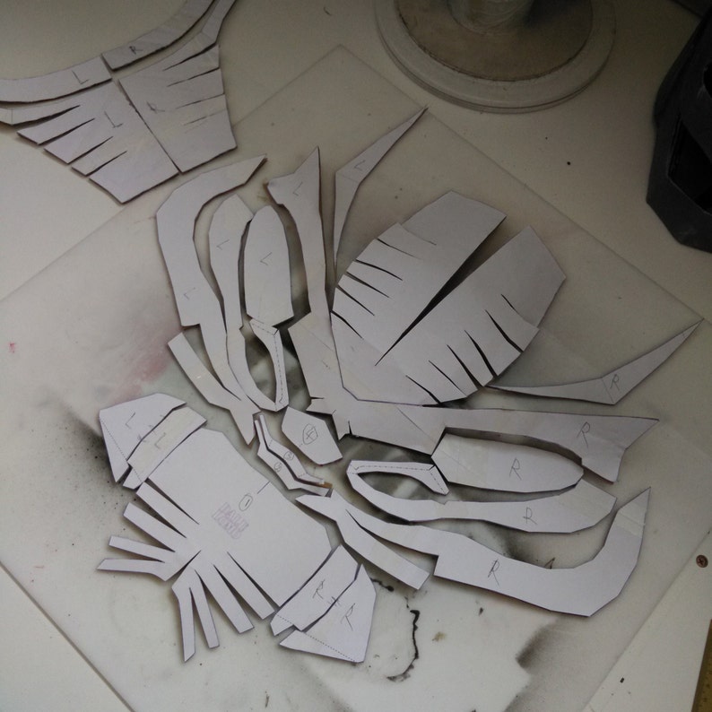 May include: A set of paper patterns for a costume, with markings for left and right sides. The patterns are laid out on a white surface.