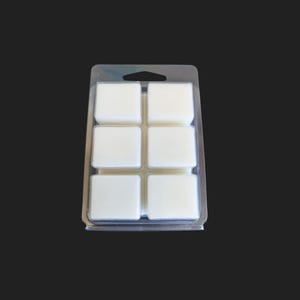 May include: A clear plastic tray with six white wax melts. The tray has a handle on the top.