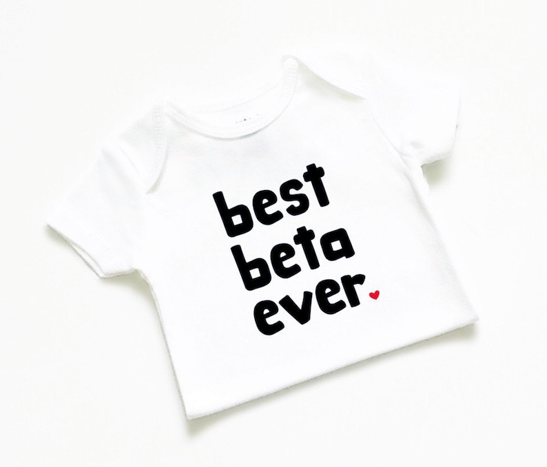 May include: White baby onesie with black text that reads "best beta ever" with a small red heart.