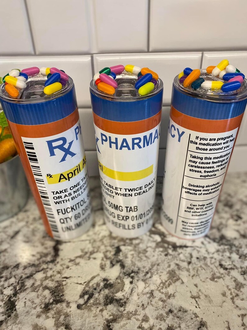 May include: Three colorful pill-shaped tumblers with a prescription label design. The labels read "Rx Pharmacy", "April A", and "Take One Tablet Twice Daily".