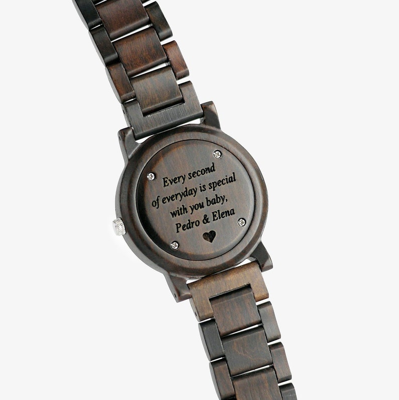 Puede incluir: Un reloj de pulsera de madera marr&oacute;n oscuro con una esfera negra y un mensaje personalizado que dice "Every second of everyday is special with you baby, Pedro & Elena".