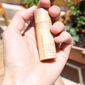 Zero-waste vegan highlighter stick in eco-friendly paper tube packaging, clean beauty makeup alternative to plastic containers.