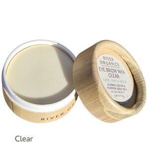 May include: A clear eye brow wax in a round, open container. The product is labeled "River Organics Eye Brow Wax Clear" with text indicating it tames, tints, and grows brows. The container is made of cardboard and contains 0.30 oz of product.