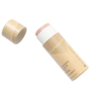 Eco-friendly cream highlighter stick with removable cap, showing zero-waste sustainable beauty packaging design.
