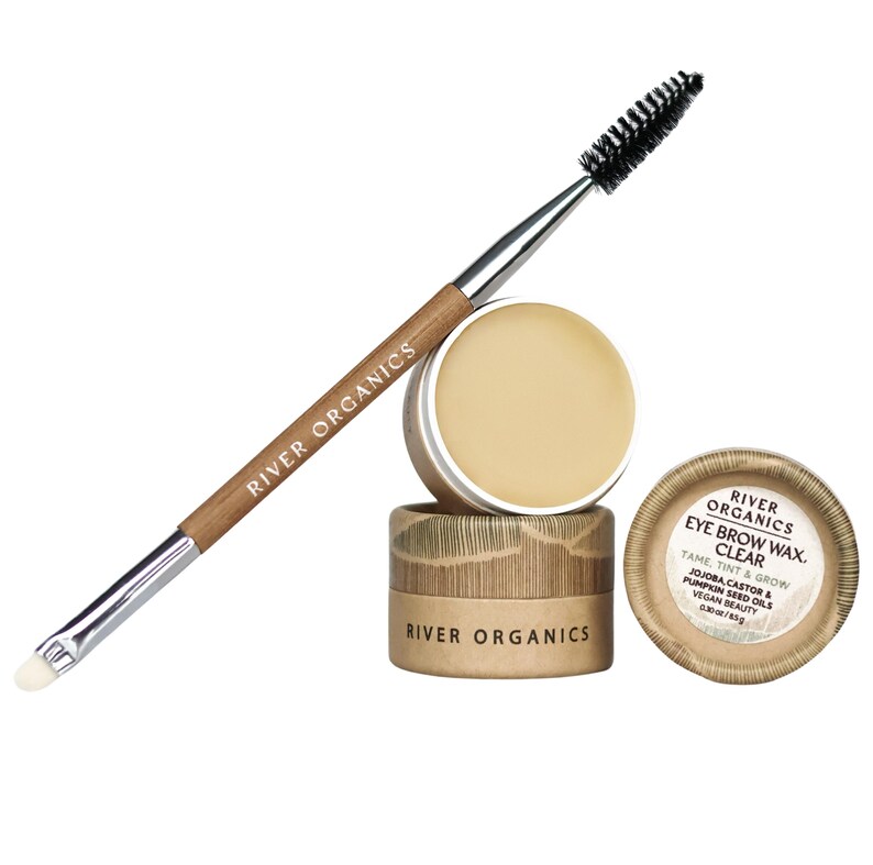 May include: A clear eyebrow wax and applicator brush set. The set includes a small jar of wax, a brush with a spoolie and angled brush, and a lid with product information. The brand name "River Organics" is visible on the brush and packaging.