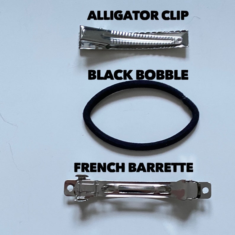 May include: Three hair accessories: a silver alligator clip, a black hair tie, and a silver French barrette.