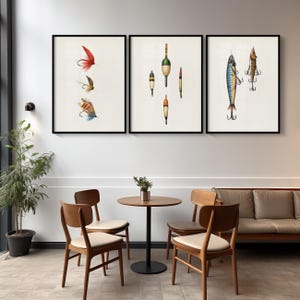 May include: Three framed art prints featuring vintage fishing lures and bobbers. The prints are in black frames and hang on a white wall. The art includes detailed illustrations of colorful fishing tackle, perfect for a rustic or nautical themed decor.