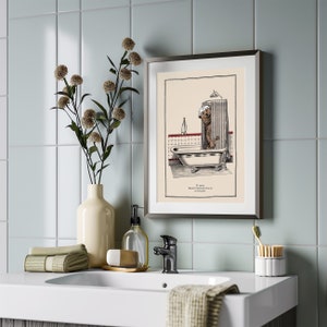 May include: A framed illustration of a bear taking a bath in a clawfoot tub. The illustration is in black and white with red accents. The text below the image reads "It couldn't be more luxurious, could it?"