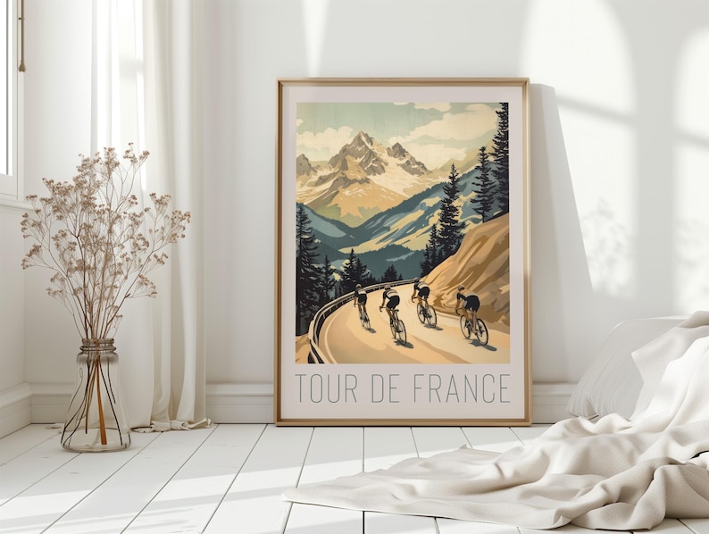 May include: A vintage-style poster with a mountain landscape and cyclists riding up a winding road. The poster is titled "Tour de France".