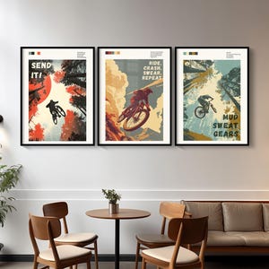 May include: Three framed mountain biking posters. The first poster says "SEND IT!" with a cyclist silhouetted against a red sun. The second poster says "RIDE, CRASH, SWEAR, REPEAT". The third poster says "MUD, SWEAT, GEARS".