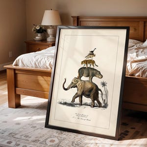 May include: Framed vintage-style print featuring an elephant, hippo, leopard, and monkey stacked on top of each other. The artwork is in a black frame and leans against a bed. The print includes text at the bottom. The room has a neutral color palette.