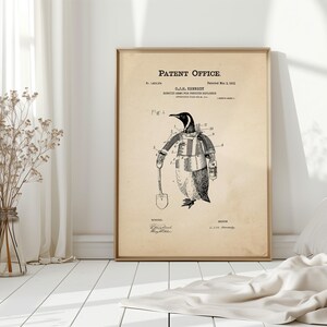 May include: A framed vintage patent print featuring a penguin in a robotic suit holding a shovel. The print is labeled "Patent Office" and includes the inventor's name and patent date. The illustration is in black and white.