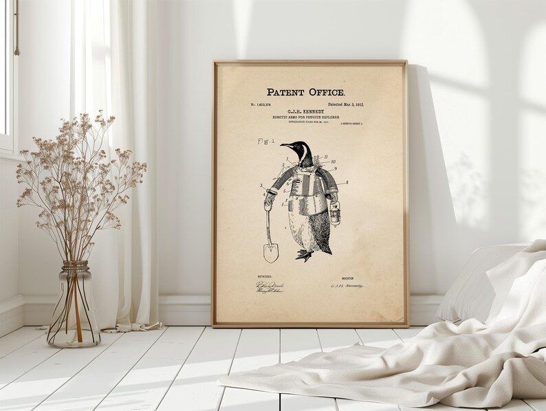 May include: A framed vintage patent print featuring a penguin in a robotic suit holding a shovel. The print is labeled "Patent Office" and includes the inventor's name and patent date. The illustration is in black and white.