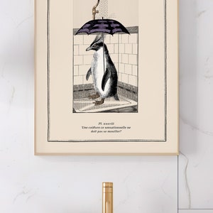 Op de afbeelding: Ingelijste kunstafdruk met een pingu&iuml;n onder een paraplu in een douche. De zwart-wit illustratie heeft een vintage esthetiek, met Franse tekst. Het kunstwerk staat boven een witte wastafel met een gouden kraan.