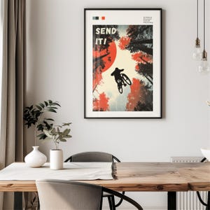 May include: Black framed poster with a mountain biker mid-air, silhouetted against a red sun and forest. The words "SEND IT!" are in bold white letters. The poster has a retro, vintage style.