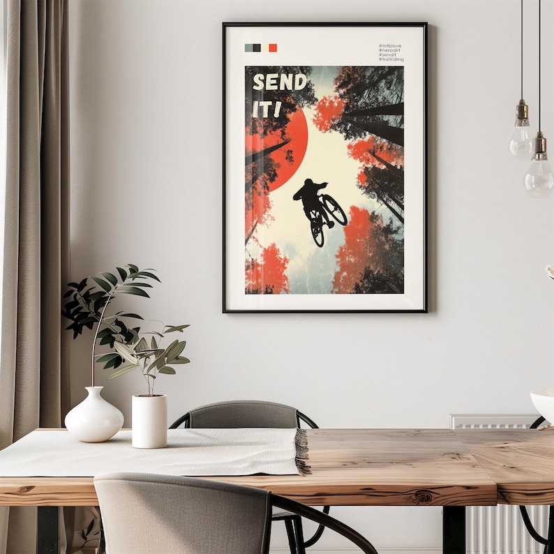 May include: Black framed poster with a mountain biker mid-air, silhouetted against a red sun and forest. The words "SEND IT!" are in bold white letters. The poster has a retro, vintage style.