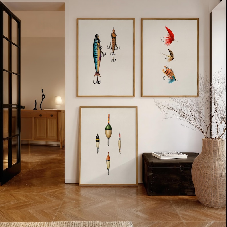 May include: Four framed art prints featuring vintage fishing lures and bobbers. The prints showcase detailed illustrations of colorful lures with hooks and bobbers in various designs. The artwork is displayed in a well-lit room with a wooden floor.