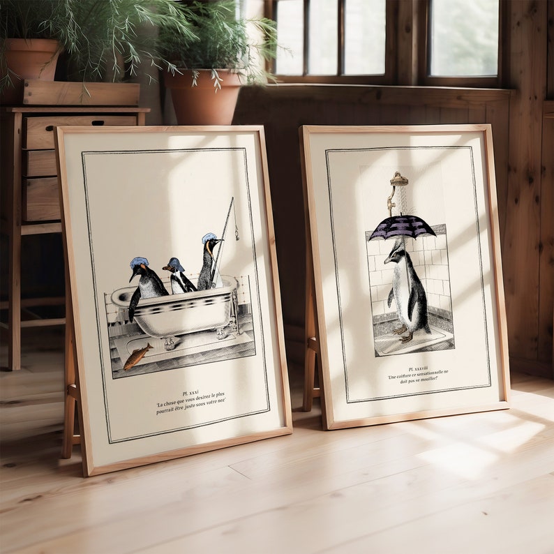 Op de afbeelding: Twee ingelijste kunstprints met pingu&iuml;n illustraties. E&eacute;n toont pingu&iuml;ns in een badkuip, de andere een pingu&iuml;n onder de douche. Beide prints hebben een vintage stijl met zwart-wit tekeningen en tekst.