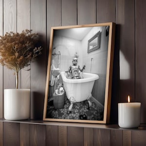May include: A black and white photograph of a robot taking a bath in a white bathtub with four legs. The robot is wearing a shower cap and is sitting in the bathtub with its arms crossed. The bathroom is tiled in white and has a small mirror on the wall.