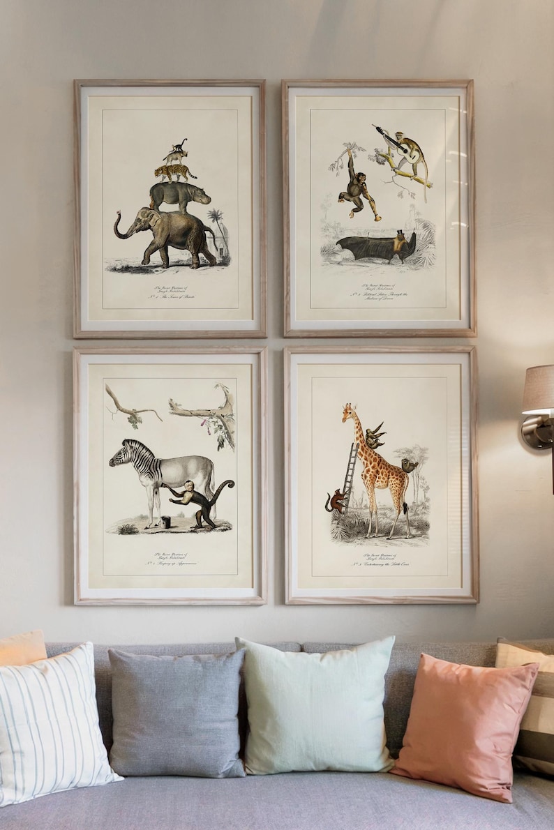 May include: Four framed vintage-style animal prints. Each print features a different animal scene, including an elephant with other animals stacked on top, a monkey swinging from a tree, a zebra with a monkey, and a giraffe with a ladder.