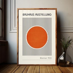 Puede incluir: Un póster a rayas blancas y negras con un gran círculo naranja en el centro. El póster dice "Bauhaus Ausstellung Weimar 1923".