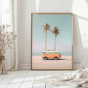May include: A vintage orange and white van with a surfboard on the roof parked on a beach with two palm trees in the background.