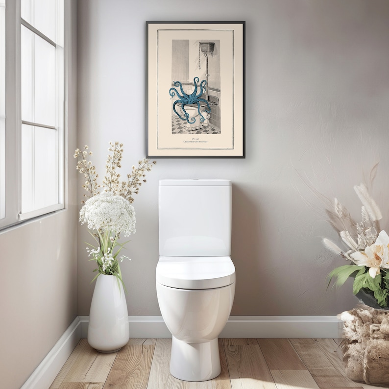 Puede incluir: Una ilustraci&oacute;n vintage de un pulpo en un inodoro. La ilustraci&oacute;n est&aacute; enmarcada y colgada en una pared de un ba&ntilde;o. El ba&ntilde;o tambi&eacute;n tiene un inodoro blanco y un jarr&oacute;n con flores blancas.