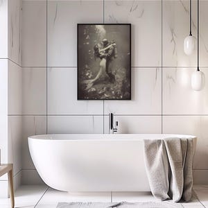 Puede incluir: Una fotograf&iacute;a en blanco y negro de una pareja bajo el agua. La mujer es una sirena y el hombre es un buzo. Se abrazan en una pose rom&aacute;ntica.