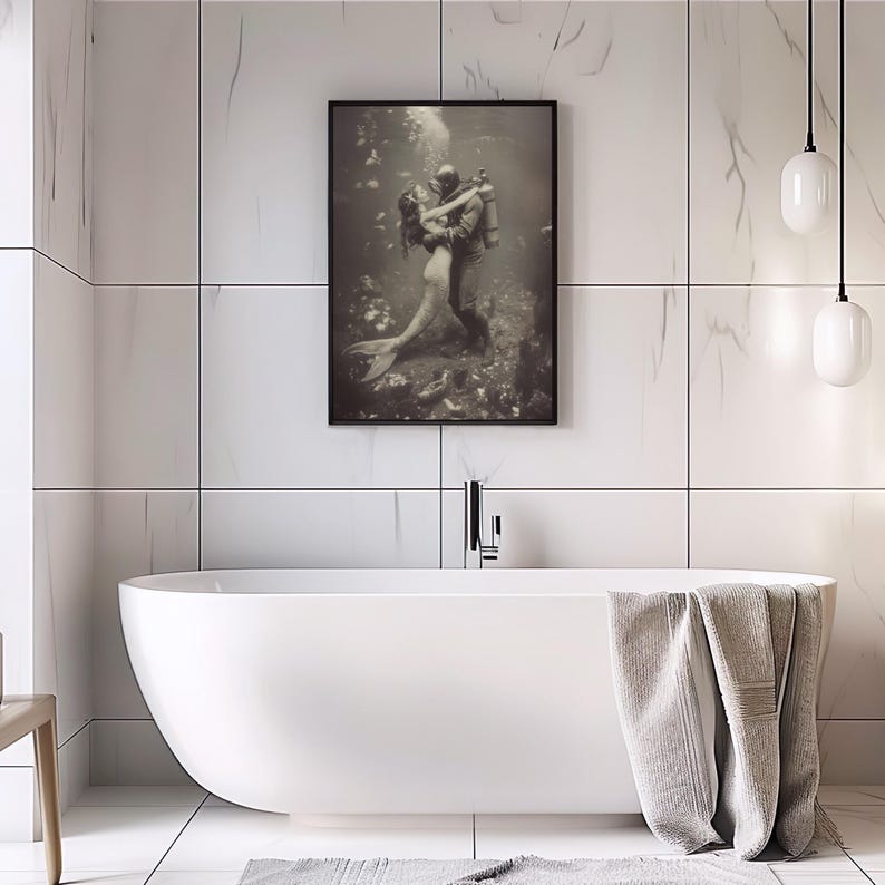 Puede incluir: Una fotograf&iacute;a en blanco y negro de una pareja bajo el agua. La mujer es una sirena y el hombre es un buzo. Se abrazan en una pose rom&aacute;ntica.