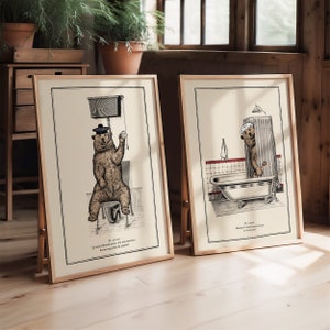 May include: Two framed illustrations of a bear in a bathroom setting. The first image shows a bear wearing a hat sitting on a toilet with the text "Je sais, j'ai d&eacute;j&agrave; dit cela, mais j'aurai besoin de beaucoup plus de papier". The second image shows a bear taking a shower with the text "Je sais, Monsieur, cette fourrure ne se lave pas".